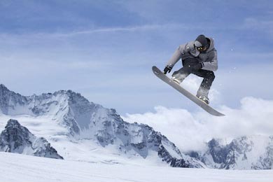 Летающий по заснеженным горам сноубордист 
