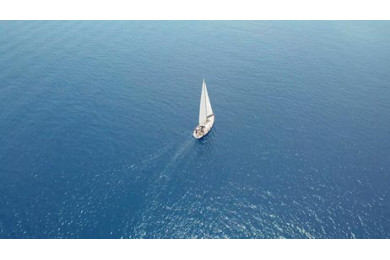 Яхта выходит в открытое море под парусом с высоты Яхта выходит в открытое море под парусом с высоты