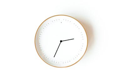 Белые часы в деревянной окантовке на белом фоне