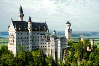 Замок Нойшванштайн в горах окруженный лесом