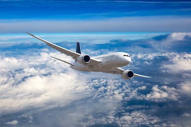 Самолет летает высоко в голубом небе над облаками Самолет летает высоко в голубом небе над облаками