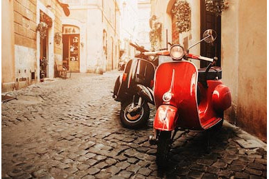 Два винтажных Веспы на стоянке старой улицы Рима Два винтажных Веспы на стоянке старой улицы Рима