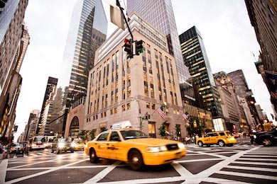Желтое такси едет по 5-й авеню в Нью-Йорке