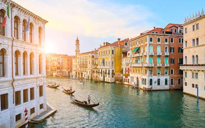 Гондольеры, плывущие через канал в Венеции