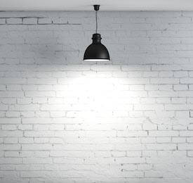 Светильник по середине на фоне белой кирпичной стены