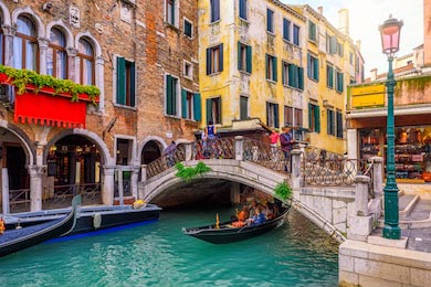 Узкий канал с гондолой и маленьким мостом в Венеции