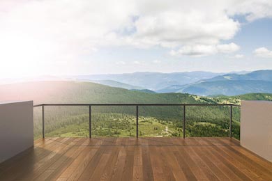 Вид с балкона на высокие горы усыпанные деревьями 