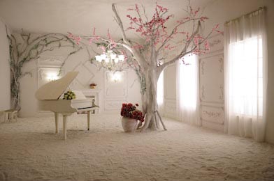 Пианино и дерево с ветвями в комнате с окнами