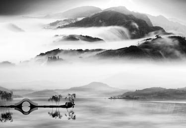 Китайского черно-белый пейзаж озера и гор в облаках