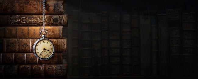 Винтажные часы, висящие на цепочке на фоне книг
