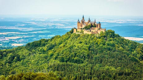 Сказочный замок Гогенцоллерн на горе среди леса 