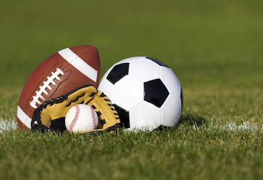 Спортивные мячи на зеленом поле