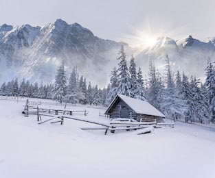 Старая ферма в горах зимним туманным утром