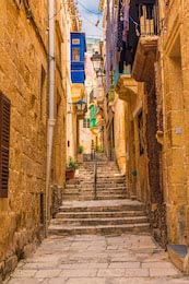 Средневековая улица с желтыми зданиями на Мальте