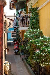 Узкая улица с цветами и велосипедом гдн-то в Италии