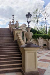 Каменная лестница в парке с перилами и фонарями