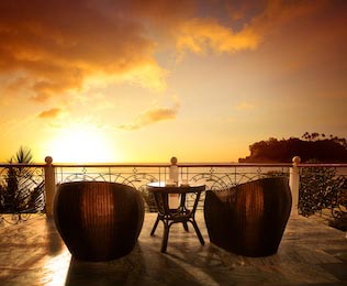 Терраса с креслами из ротанга и видом на море
