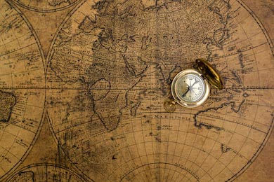 Старый компас лежащий на желтой винтажной карте
