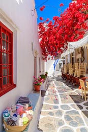 Узкая улица с украшенными цветами домами на Миконосе