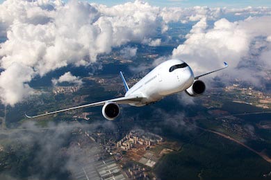 Белый пассажирский самолет поднимается сквозь облака