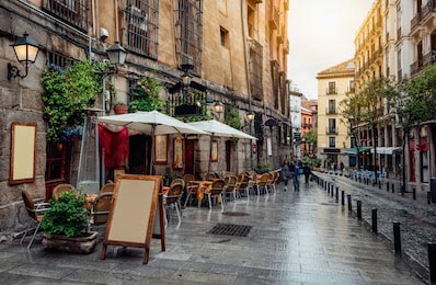 Старая уютная улица с летним кафе в Мадриде, Испания