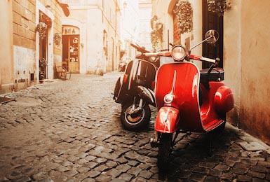 Скутеры Vespa на стоянке на старой улице в Риме