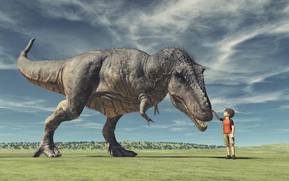 Маленький мальчик гладит большого динозавра