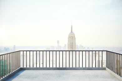 Балкон с перилами и туманный вид на город Нью-Йорк