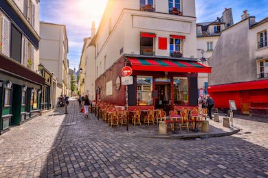 Уютная улица со столами кафе в квартале Монмартр