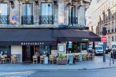 Посетитель в парижском кафе у тротуара с кофе