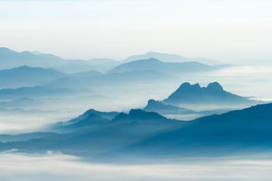 Силуэты горных хребтов в густом тумане