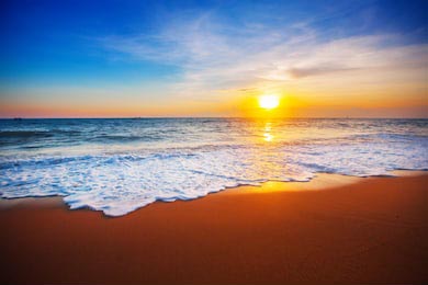 Заката солнца на пляже с пенными волнами