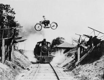 Ретро черно-белое фото опасного прыжка над паровозом